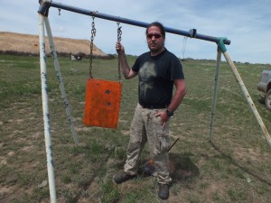The author standing next to the 1,000 yard target. You can see each hit from the 3-shot group.